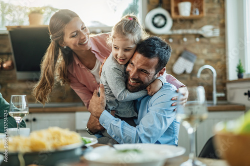 Fotomural Young loving family embracing in dining room.