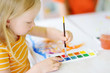 © MNStudio - Cute girl drawing with colorful paints. Creative kid painting at home. Education and distance learning for kids. Homeschooling during quarantine. Stay at home entertainment.
