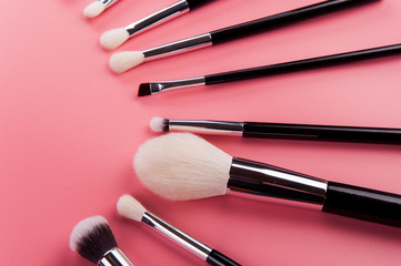 Make up brush lie on a pink background