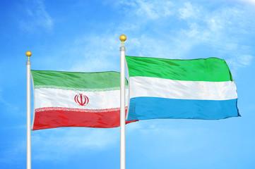 Iran and Sierra Leone two flags on flagpoles and blue cloudy sky