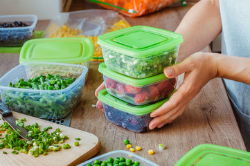 Close up of woman preparing plastic food boxes for freezing