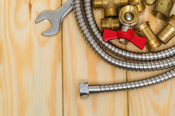 Plumbing spare parts, faucet, tool and hose on wooden boards are used to replace or repair