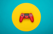 Red Gamepad On Blue  Background With Yellow Circle. Gaming, Leisure And Entertainment Concept. Top View