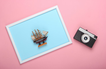 Canvas Print - Retro camera and toy ship on pink background with photo  frame. Studio shot. Creative flat lay, travel. Top view. Minimalism