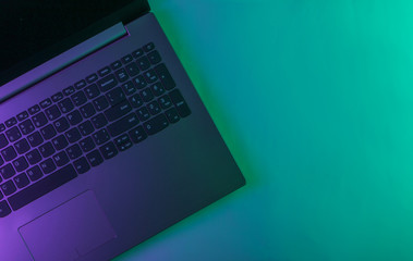 Laptop with neon green purple light. Gradient glow. Top view