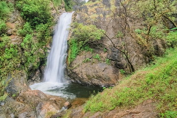 view of silky waterfall flowing on cliff rocks around with green forest background, Mae Pan Waterfall, Doi Inthanon National Park, Chiang Mai, northern of Thailand.