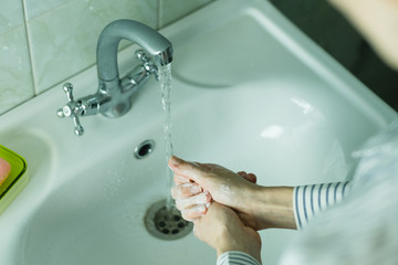 Cleaning hands with soap and water.