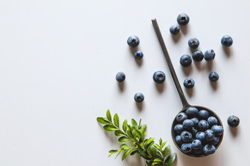 Blueberries in a spoons isolated on a white background. Healthy food, health