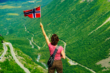 Wall Mural - Tourist with norwegian flag on Trollstigen viewpoint