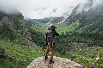 Photographer taking picture of mountain valley in summer season, Pin Bhaba pass trek in Shimla, north India