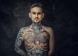 © Fxquadro - Cool tattoo artist posing in a dark studio with a half-naked body wearing jeans, tattooed in a japanese irezumi style, looking cool and confident. Close up portrait