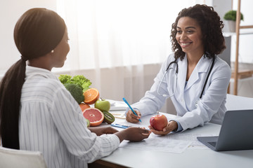 Happy nutritionist giving consultation to patient about healthy feeding