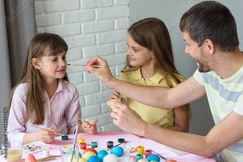 Dad paints his nose for daughter while painting Easter eggs