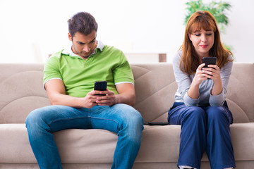 Young couple in gadget dependency concept