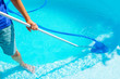 swimming pool cleaning. a man is cleaning the pool. service care