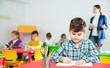 © JackF - Preteen boy studying in classroom on background with classmates and teacher