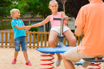 Wall Mural - children are teetering on the swing in the playground.