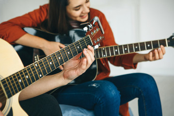 learning to play the guitar. the teacher explains to the student the basics of playing the guitar. i