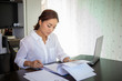 © tuiphotoengineer - Beautiful Asian business women checking document and using notebook for working at home