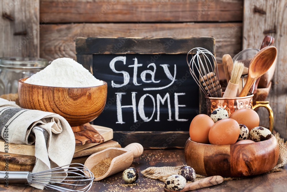 Baking ingredients and board with social notice stay at home - obrazy, fototapety, plakaty 