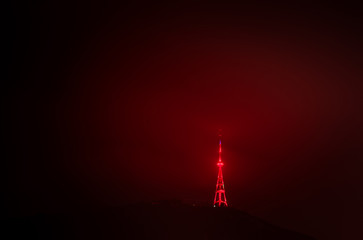 Illiuminated red television tower and funicular up the hill in Tbilisi, Georgia. Background  blank space image. 22.03.2020