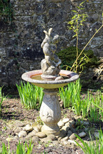 An Ornamental Stone Fountain In A Garden