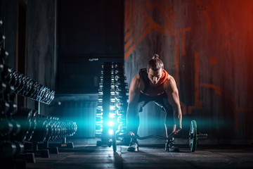 young athlete has physical workout with barbell in modern gym