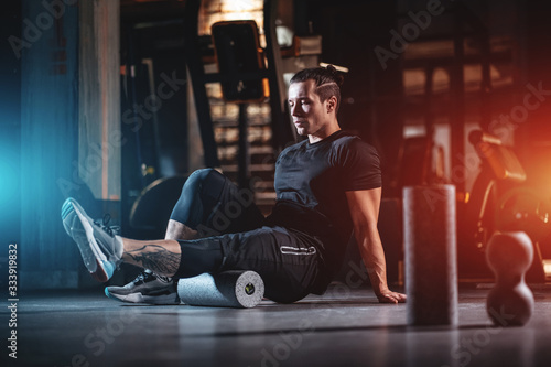Fotomural young man has crossfit workout with roller and weight in gym