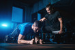 young man has workout with personal trainer in modern gym