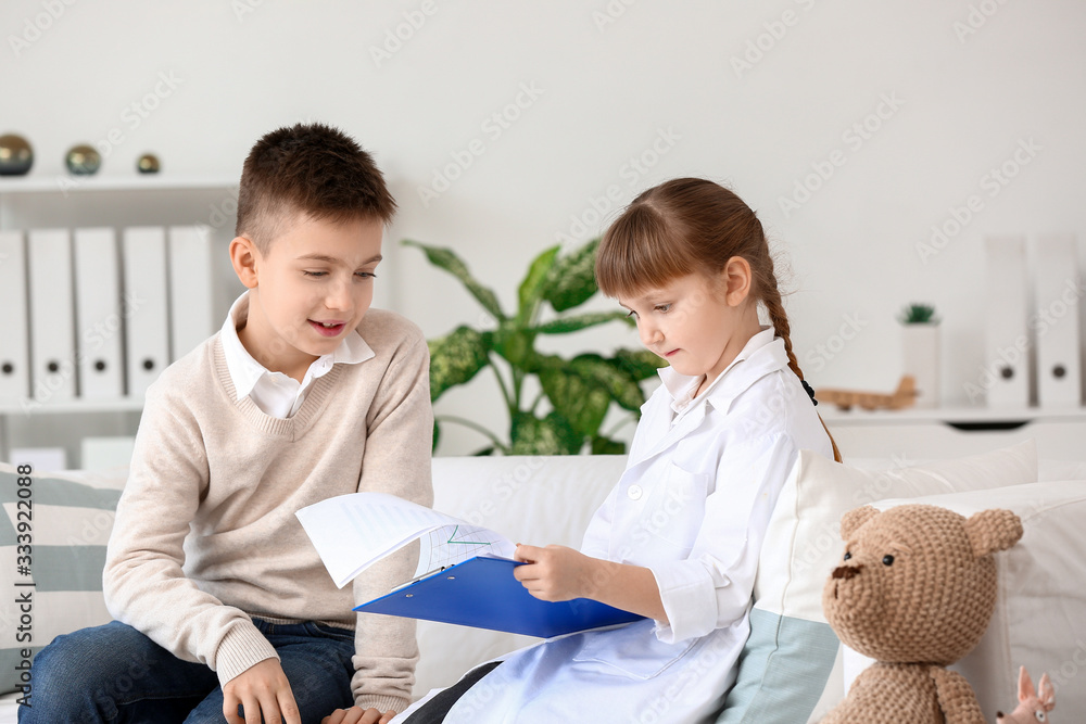 Cute little doctor working with patient in clinic