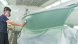 Repairman fixing by painting boat body and painting boat using spray gun