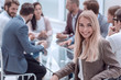 © ASDF - smiling young woman sitting at table in conference room