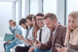 © ASDF - group of diverse young people sitting in the office lobby