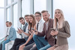 © ASDF - group of young employees sitting in the office corridor.
