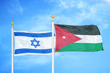 Israel and Jordan two flags on flagpoles and blue cloudy sky