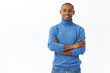 © Cookie Studio - Portrait of professional, confident african american bold guy in blue turtleneck smiling pleased, making good profit, big investment, standing white background satisfied