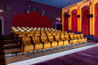 Large cinema theater interior with seat rows for audience to sit in movie theater premiere by cinematograph projector. The cinema theater is decorated in classical for luxury feel of movie watching.