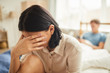© Seventyfour - Portrait of frustrated young woman crying in bedroom with husband in background, couple fight, copy space