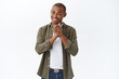 © Cookie Studio - Portrait of young happy african-american man smile and appreciate help, thanking for praises, shaking clasped fingers, feel grateful and delighted, standing white background