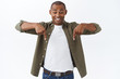 © Cookie Studio - Portrait of cheerful, excited happy man, african american male pointing down, seeing good offer, special discount, finally found good deal, standing white background amazed