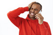 © Cookie Studio - Close-up portrait of bothered young grimacing african-american man forgot about date, punch head and squinting, talking to friend on smartphone, calling person mobile phone to apologize