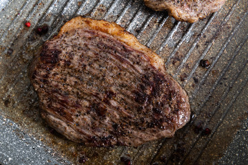 Grilled beef steak ribeye on a pan with salt and pepper