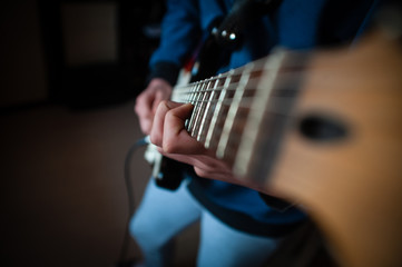 Wall Mural - Male hands playing electric solo guitar with closeup photo. Learning musical instrument, music shop or school, blues bar or rock cafe, having fun enjoying hobby concept