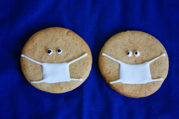  emoticons from ginger cookies in medical masks on a blue background