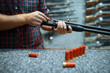 © Nomad_Soul - Male person with rifle loads ammo in gun shop