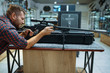 © Nomad_Soul - Man aims with sniper rifle in gun shop