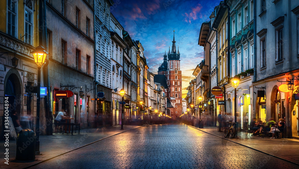 Evening view of St. Mary's Basilica from the Florianska street, old town Krakow, Poland. Panoramic view, long exposure, timelapse. - obrazy, fototapety, plakaty 