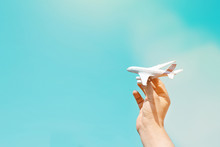 Hand Of A Man Holding A Plane. Concept Of Tourism, Travel, Business. Panoramic View With Copy Space For Travel Agency Banner Or Poster