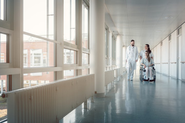 Poster - Doctor, nurse, and patient in wheelchair on hospital corridor