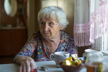 An elderly woman pensioner sitting at the table.